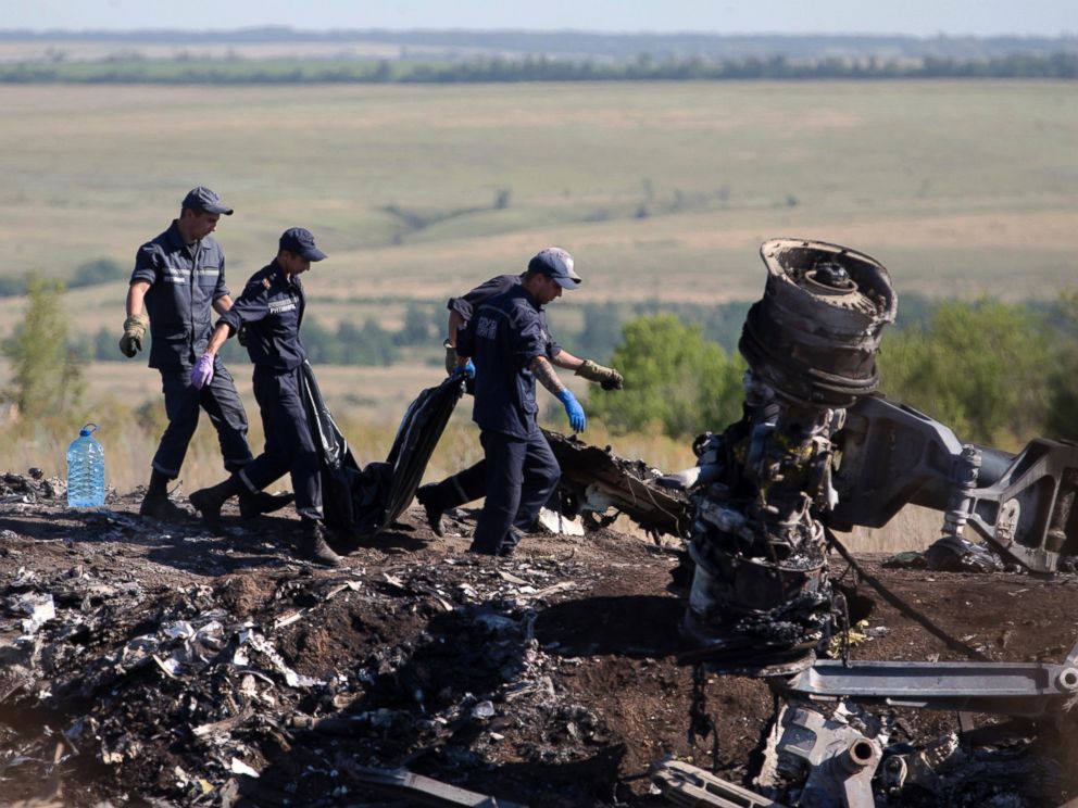 PHOTO: Ukrainian Emergency workers carry a victims body in a plastic bag at the crash site of Malaysia Airlines Flight 17 near the village of Hrabove, Donetsk region, eastern Ukraine, July 21, 2014.