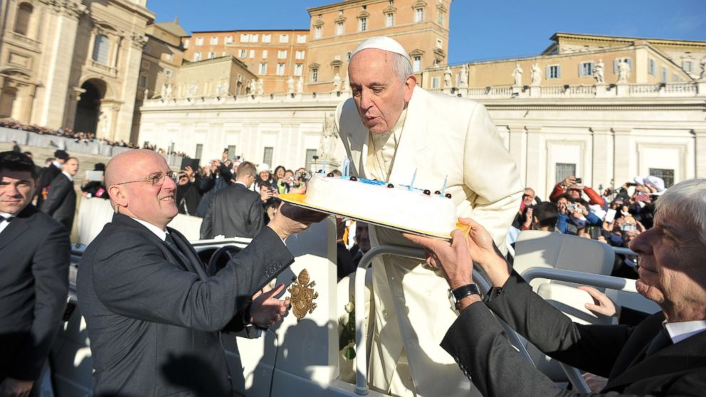 In this photo provided by Vatican newspaper L'Osservatore Romano, Pope Francis blows candles on a cake during his weekly general audience in St. Peter's Square at the Vatican on Dec. 17, 2014.