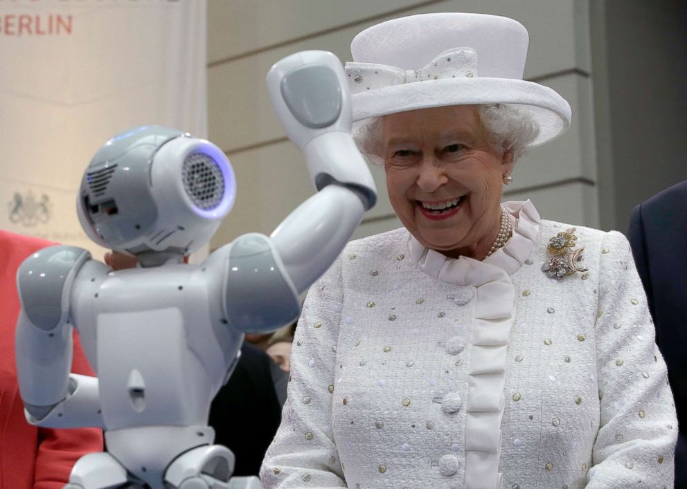 PHOTO: Britain's Queen Elizabeth II smiles as a robot waves to the her during a reception at the 'Technische Universitaet' (Technical University) in Berlin, on June 24, 2015.