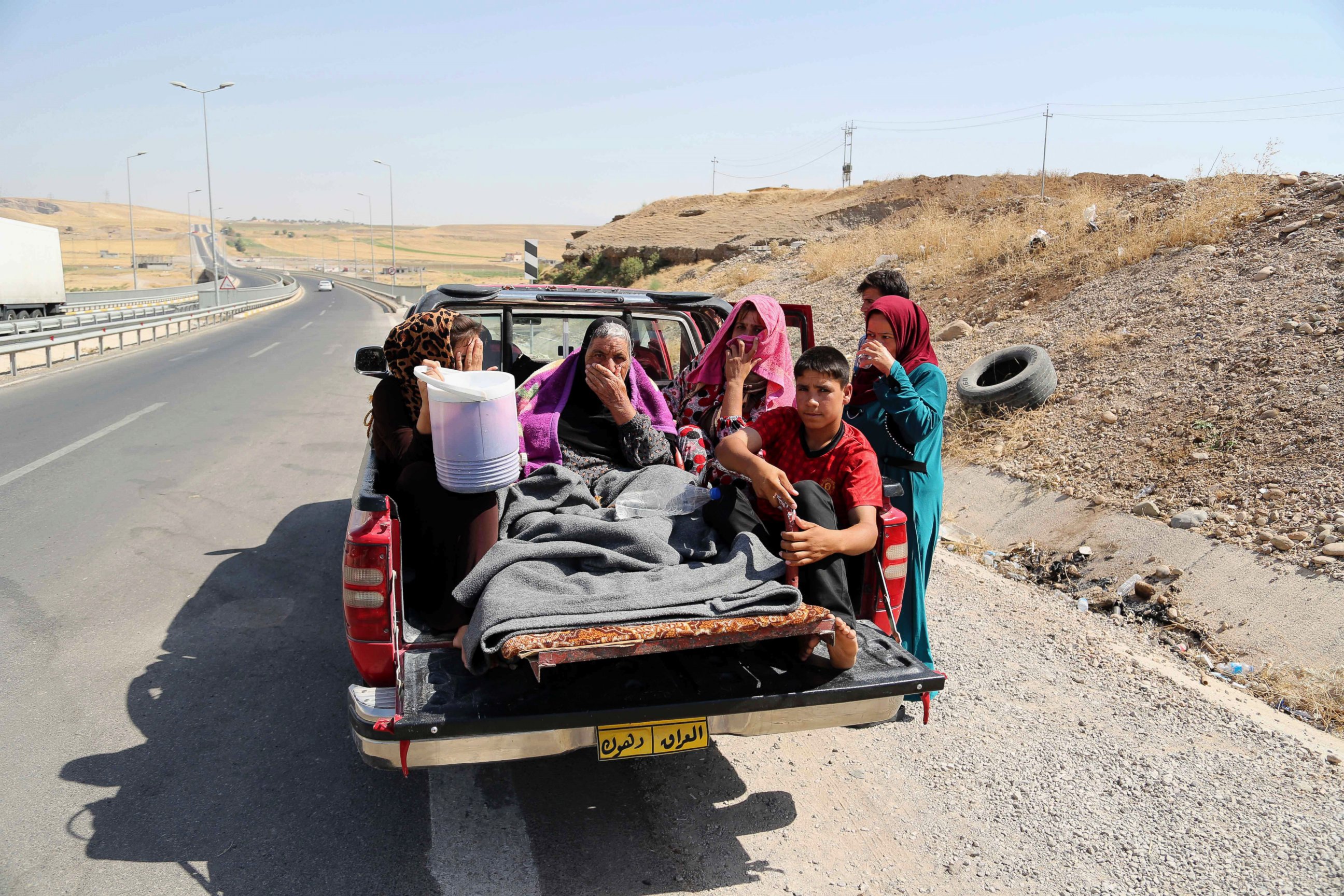 PHOTO: Displaced Iraqis ride on a truck on a mountain road near the Turkish-Iraq border, outside Dahuk, in Iraq Saturday, Aug. 9, 2014.