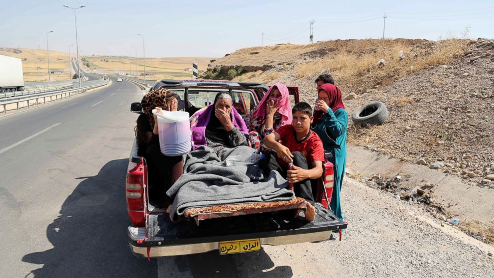 PHOTO: Displaced Iraqis ride on a truck on a mountain road near the Turkish-Iraq border, outside Dahuk, in Iraq Saturday, Aug. 9, 2014.