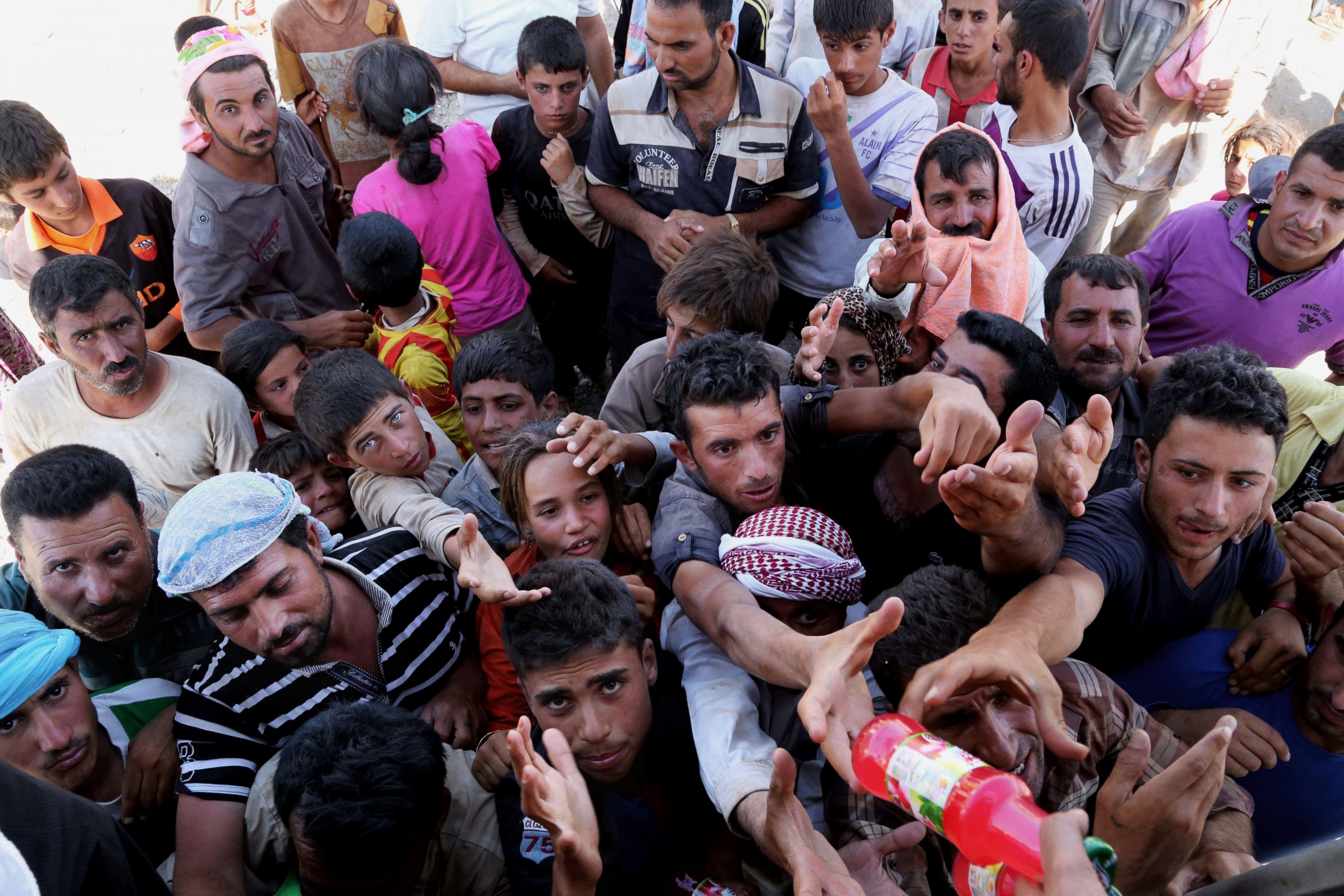 PHOTO: Displaced Iraqis from the Yazidi community gather for humanitarian aid at the Iraq-Syria border at Feeshkhabour border point on August 10, 2014.