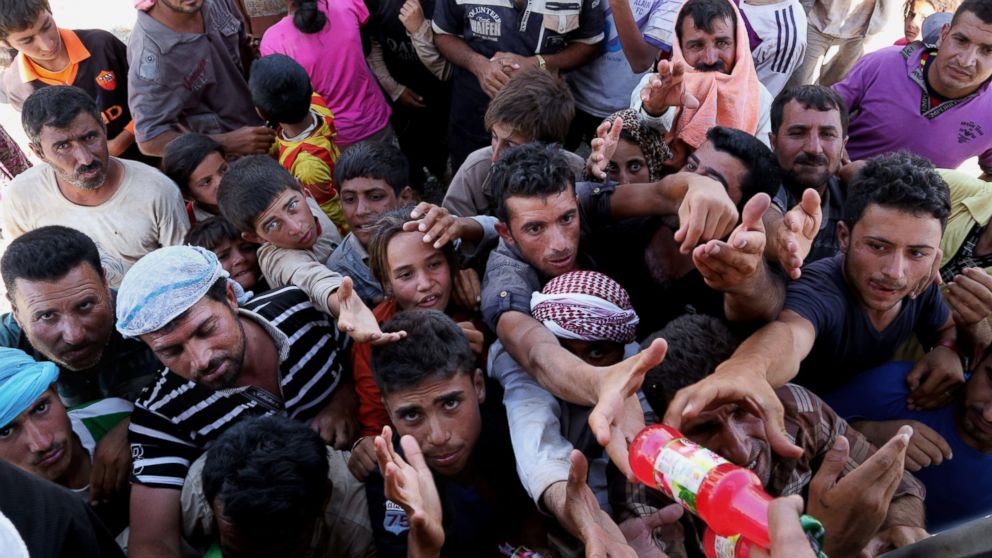 PHOTO: Displaced Iraqis from the Yazidi community gather for humanitarian aid at the Iraq-Syria border at Feeshkhabour border point on August 10, 2014.