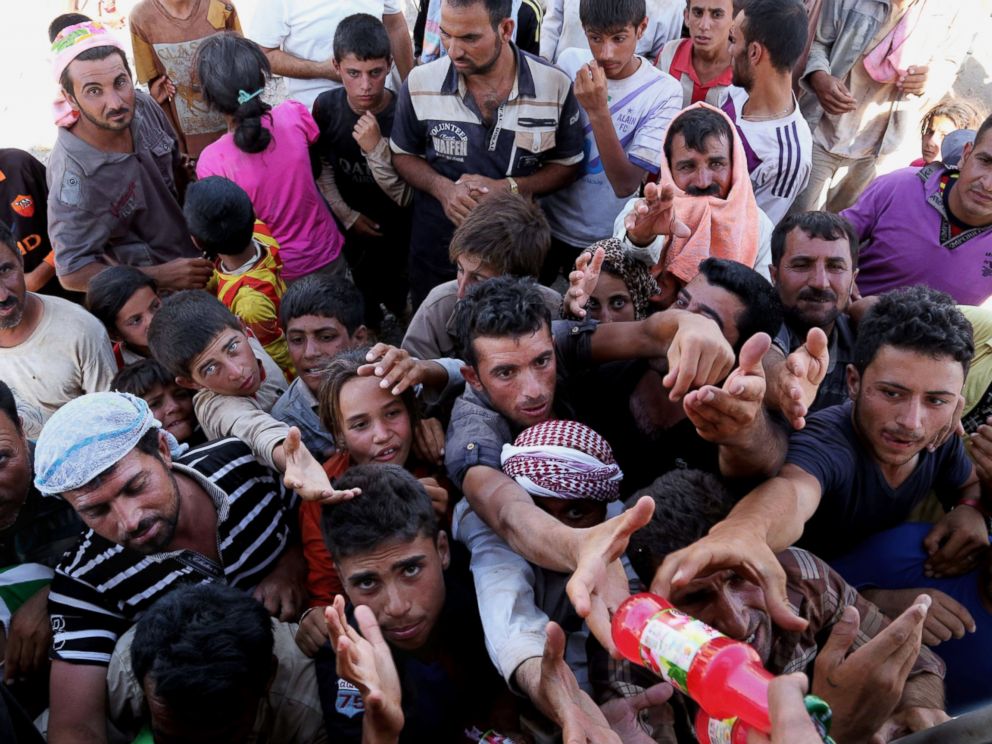 PHOTO: Displaced Iraqis from the Yazidi community gather for humanitarian aid at the Iraq-Syria border at Feeshkhabour border point on August 10, 2014.