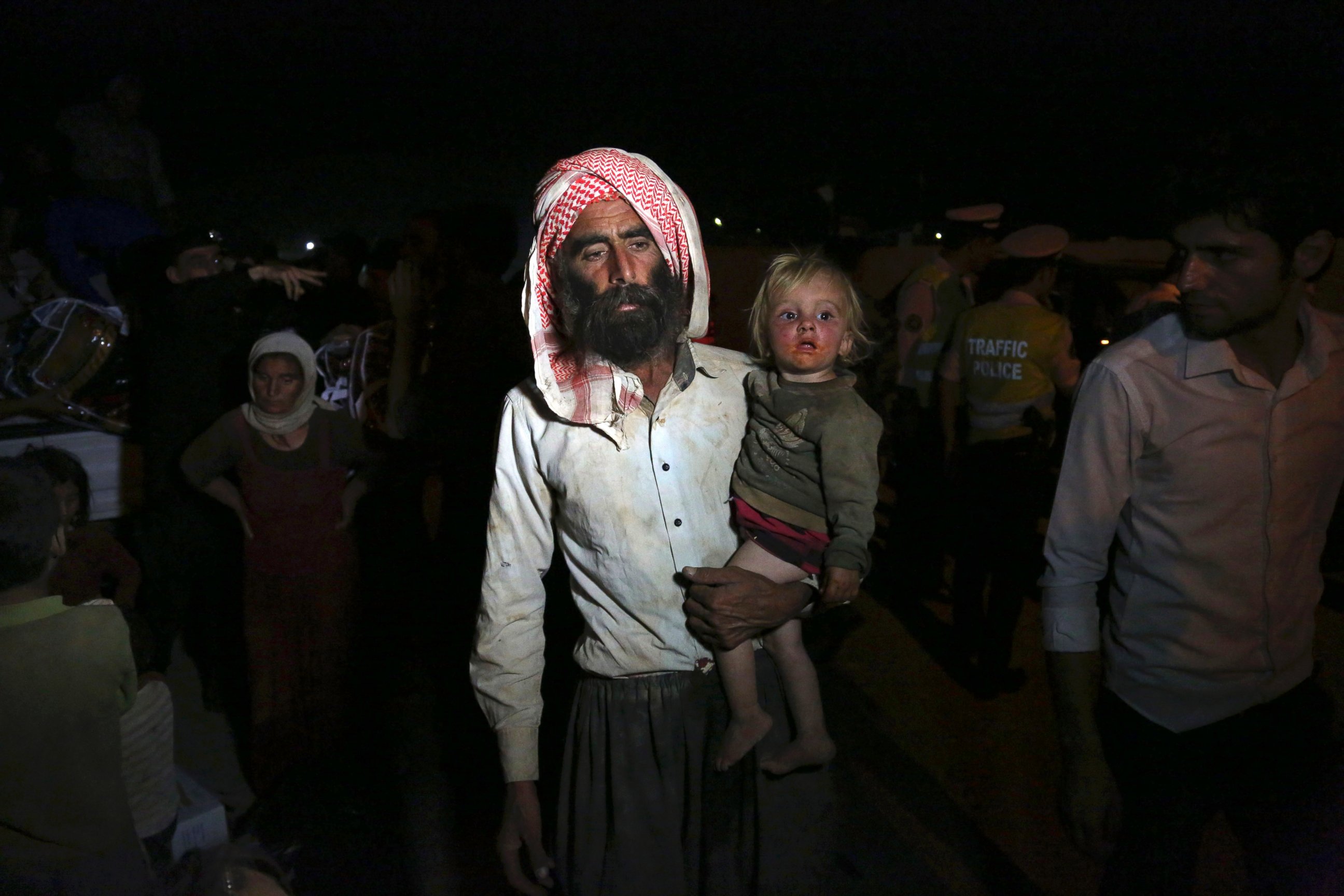 PHOTO: Displaced Iraqis from the Yazidi community cross the Syria-Iraq border at Feeshkhabour border point, in northern Iraq, Aug. 10, 2014.