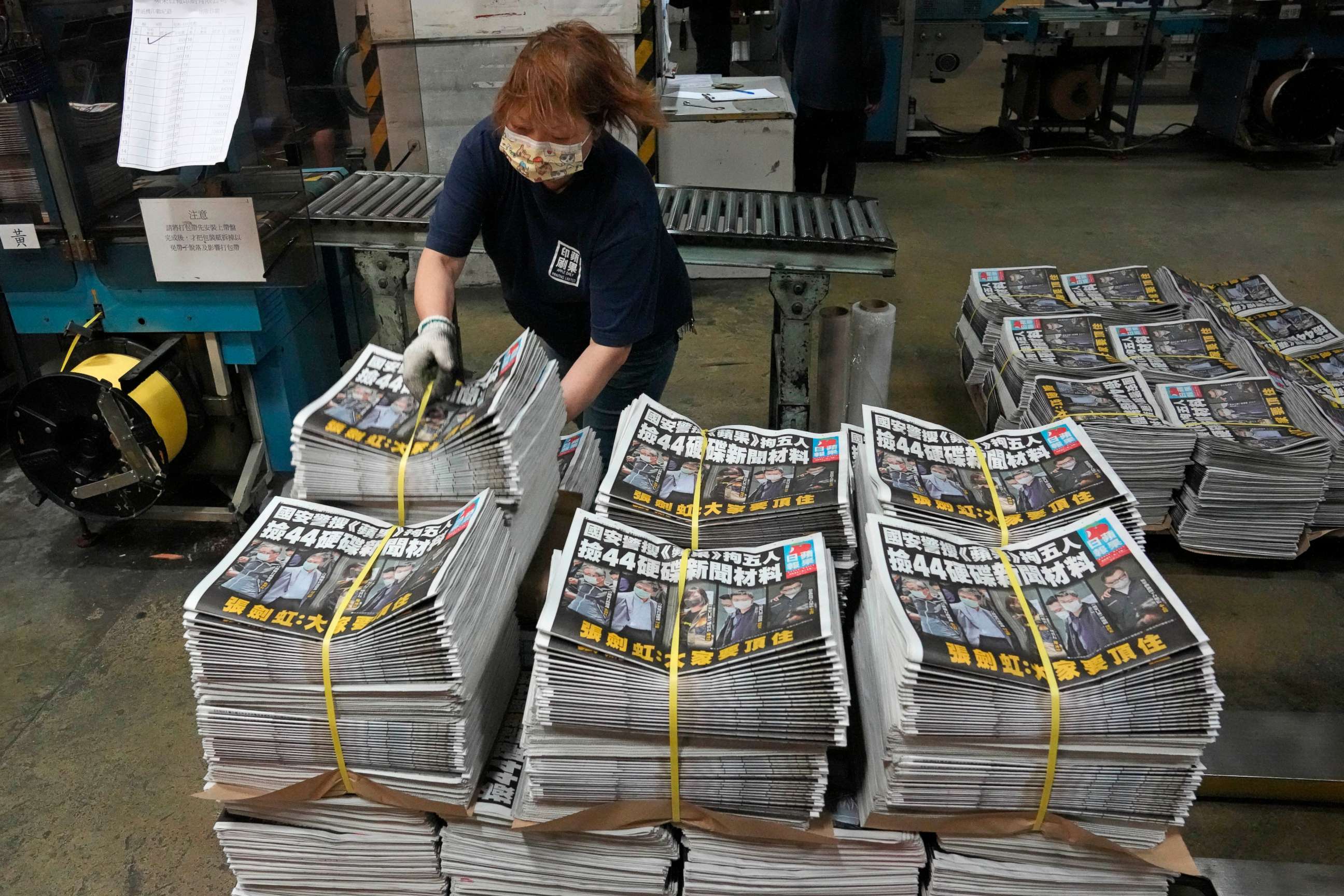 PHOTO: FILE - In this Friday, June 18, 2021, file photo, a worker packs copies of the Apple Daily newspaper at the printing house in Hong Kong. 