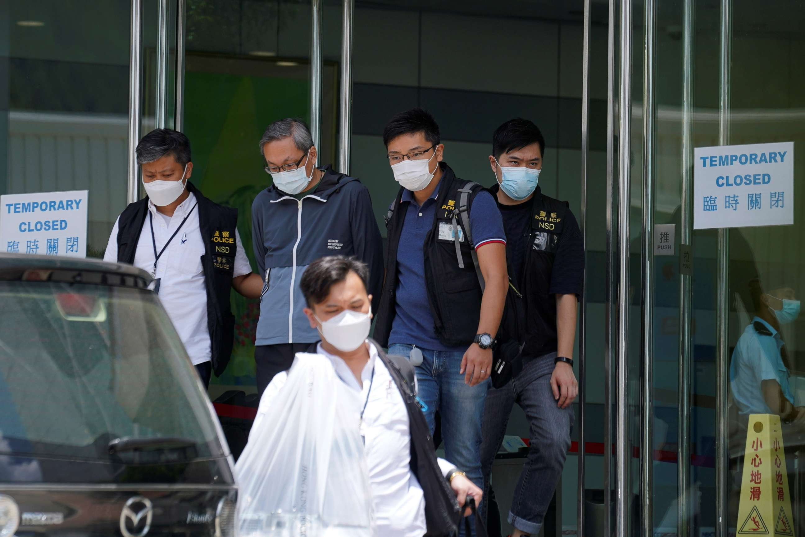 PHOTO: Police officers from the national security department escort Apple Daily's Chief Executive Officer Cheung Kim-hung from the offices of Apple Daily and Next Media in Hong Kong, China, June 17, 2021.