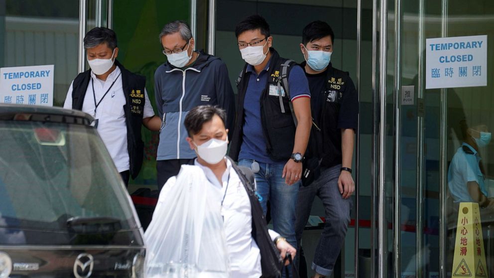 PHOTO: Police officers from the national security department escort Apple Daily's Chief Executive Officer Cheung Kim-hung from the offices of Apple Daily and Next Media in Hong Kong, China, June 17, 2021.