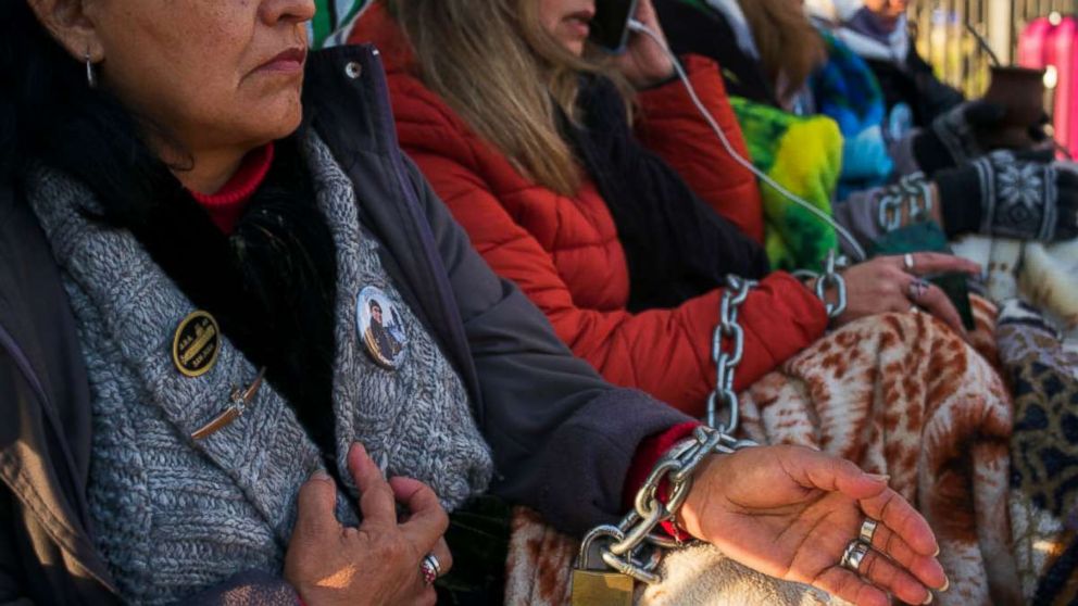 Relatives of the ARA San Juan crew with hands chained look on during a protest in front of the Casa Rosada demanding the government to continue the search for the lost submarine on June 28, 2018 in Buenos Aires, Argentina.