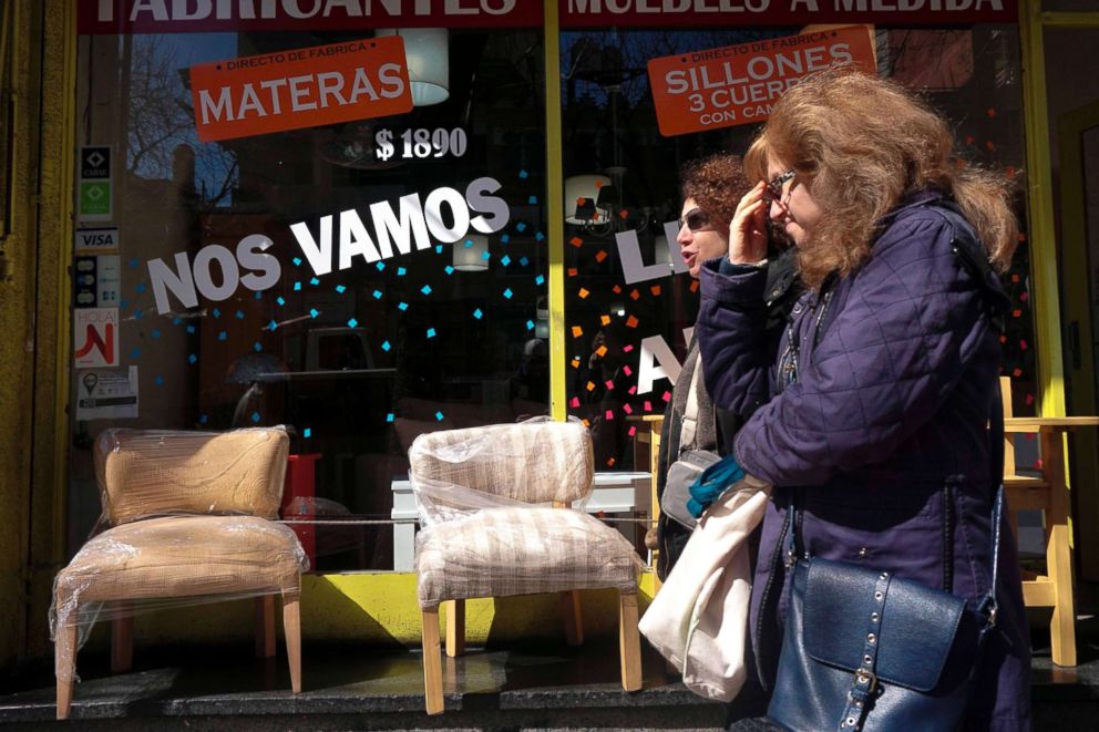 PHOTO: Women walk past a store reading "We Are Leaving" in Buenos Aires, Sept. 4, 2018. 