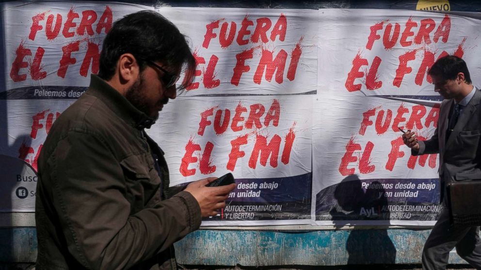 PHOTO: People walk past posters rejecting the government's negotiations with the International Monetary Fund (IMF), in Buenos Aires, Sept. 4, 2018.