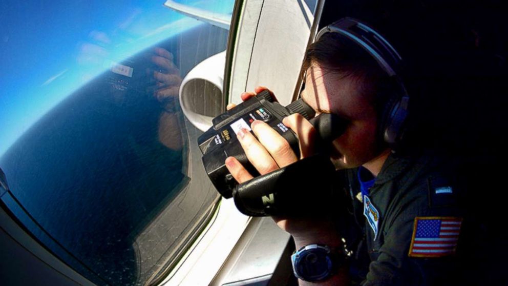 PHOTO: A U.S. Navy member uses binoculars from an aircraft searching for Argentina's missing ARA San Juan submarine in the Southern Atlantic, after leaving a base in Bahia Blanca, Argentina, Nov. 27, 2017. 