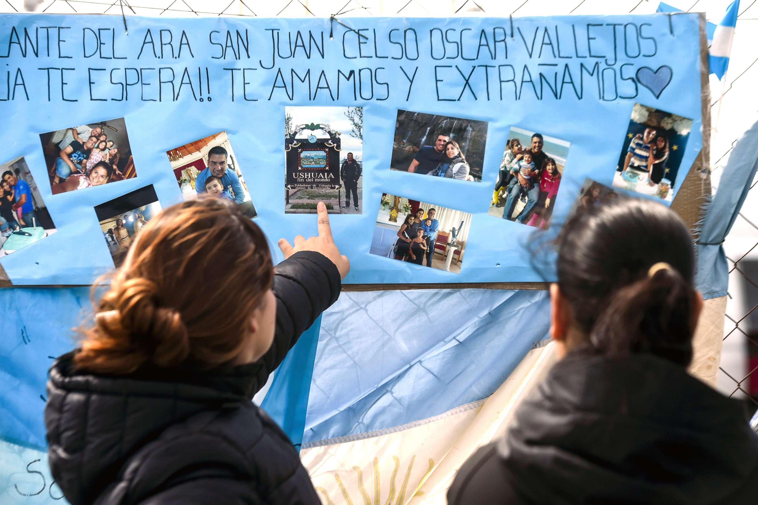 PHOTO: Women look at family pictures of missing Argentine submarine crew member Cesar Oscar Vallejos, hanging outside Argentina's Navy base in Mar del Plata, on the Atlantic coast south of Buenos Aires, on Nov. 24, 2017.
