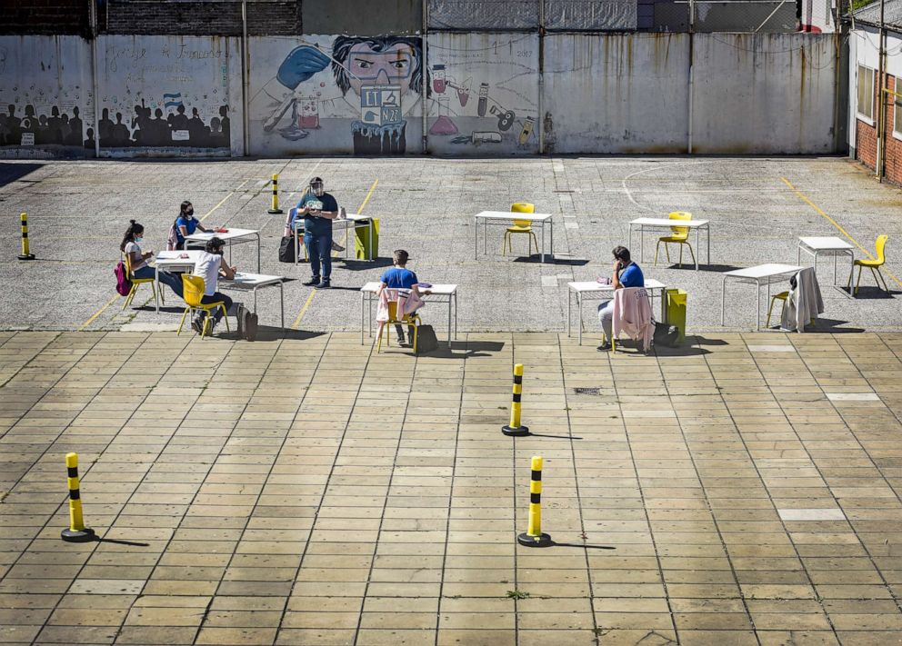 PHOTO: Students wearing protective masks and keeping social distance participate in a class in the schoolyard on Oct. 13, 2020 in Buenos Aires, Argentina. 