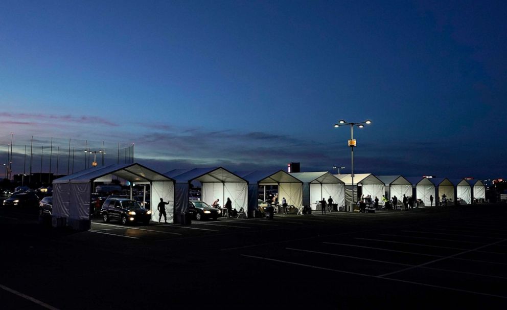 PHOTO: A row of tents are set up so people who have registered can get their COVID-19 vaccinations as they drive-thru the parking lot of the State Farm Stadium, Jan. 12, 2021, in Glendale, Ariz.