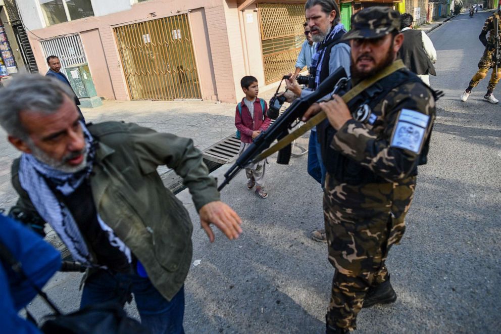 PHOTO: A member of the Taliban special forces pushes a journalist covering a demonstration by women protestors outside a school in Kabul, Afghanistan, on Sept. 30, 2021.