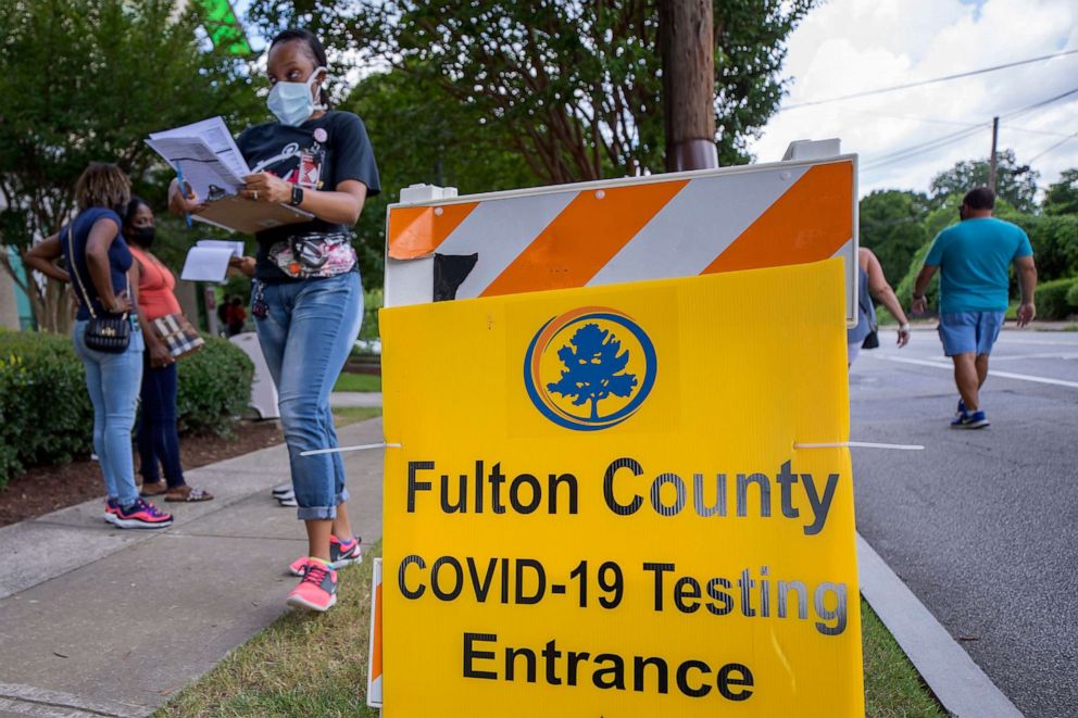 PHOTO: People wait in line at a walk-up COVID-19 testing site operated by Fulton County at the Center for Health and Rehabilitation in Atlanta, July 9, 2020.