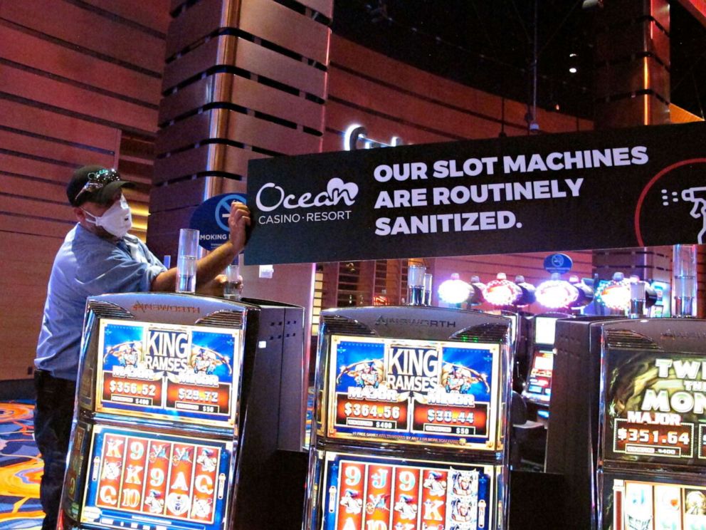 PHOTO:A worker at the Ocean Casino Resort in Atlantic City N.J., June 3, 2020, installs a sign indicating that slot machines will routinely be sanitized once the casino reopens to prevent the spread of the coronavirus.