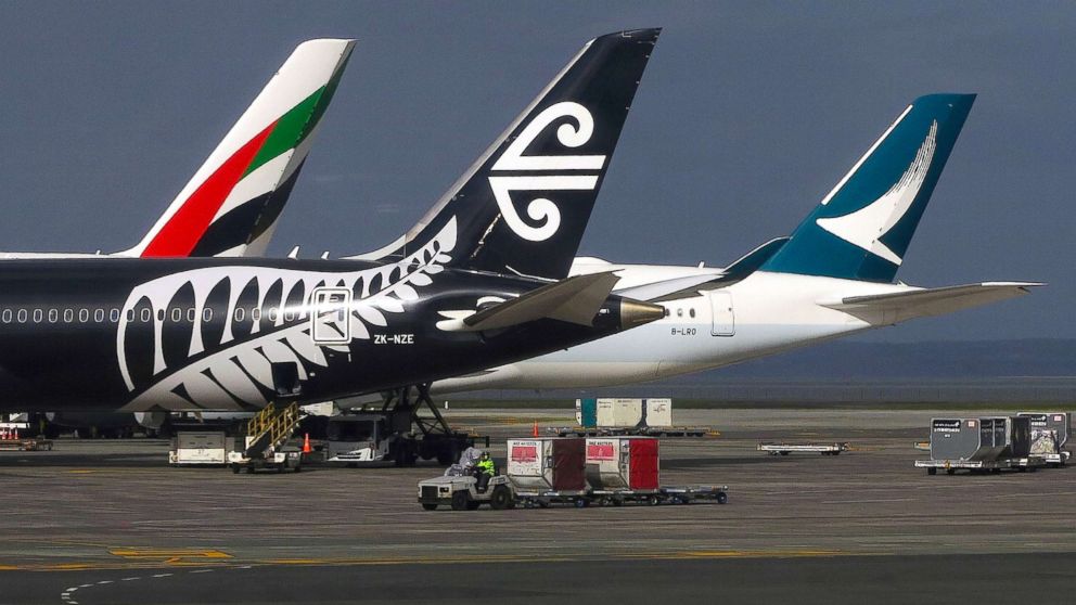 A worker drives a vehicle across the tarmac past aircraft bearing the logos of Emirates, Air New Zealand and Cathay Pacific airlines at Auckland Airport in New Zealand, June 25, 2017. 