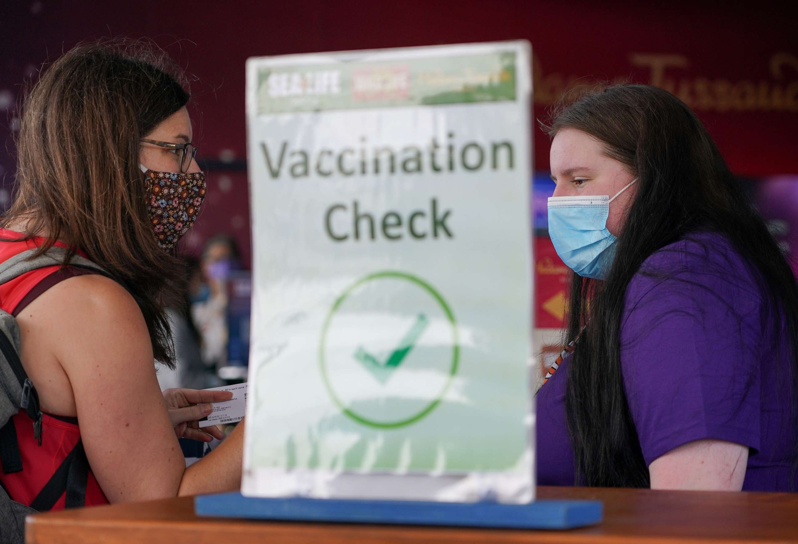PHOTO: A staff member attends to a visitor at a vaccination check station at SEA LIFE Sydney following an extended closure due to coronavirus disease (COVID-19) lockdown orders, in Sydney, Australia, October 14, 2021. 