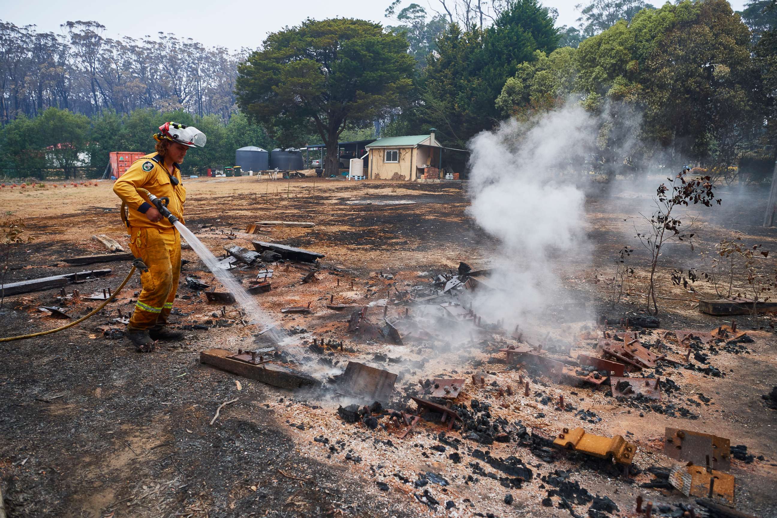 PHOTO: An RFS Crew attempts to put out a smoldering pile of railway sleepers. The sleepers measured over 600 degrees on a thermal temperature gauge two days after the fire front had passed through on Jan. 6, 2020 in Wingello, Australia.