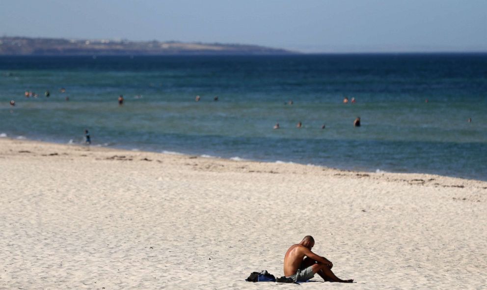 PHOTO: A beachgoer sits in the sun on Glenelg Beach in Adelaide, Australia, Jan. 24, 2019.