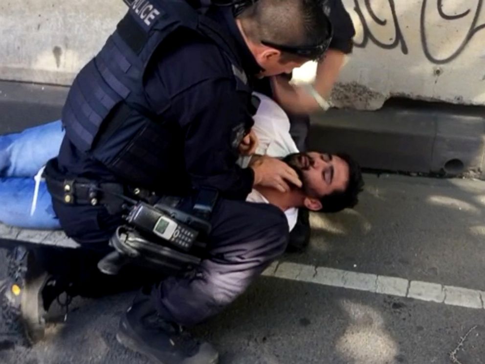 PHOTO: A police officer detains a man that was pulled from the car that rammed pedestrians at Flinders St station in Melbourne, Australia, Dec. 21, 2017.