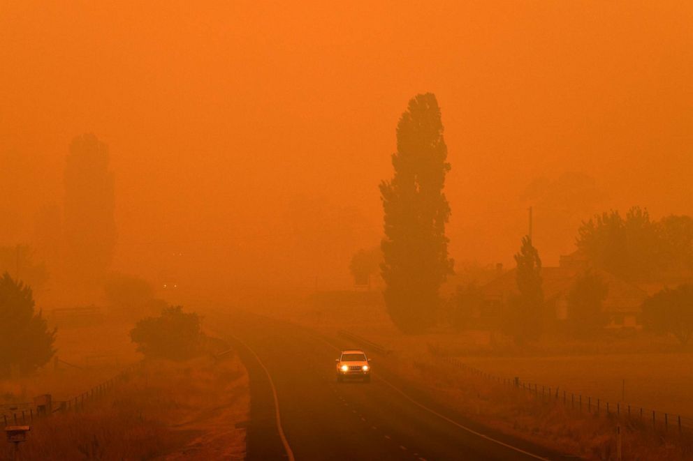 PHOTO: A car travels on a road through thick smoke from bush fires in Bemboka, in Australia's New South Wales state, Jan. 5, 2020.