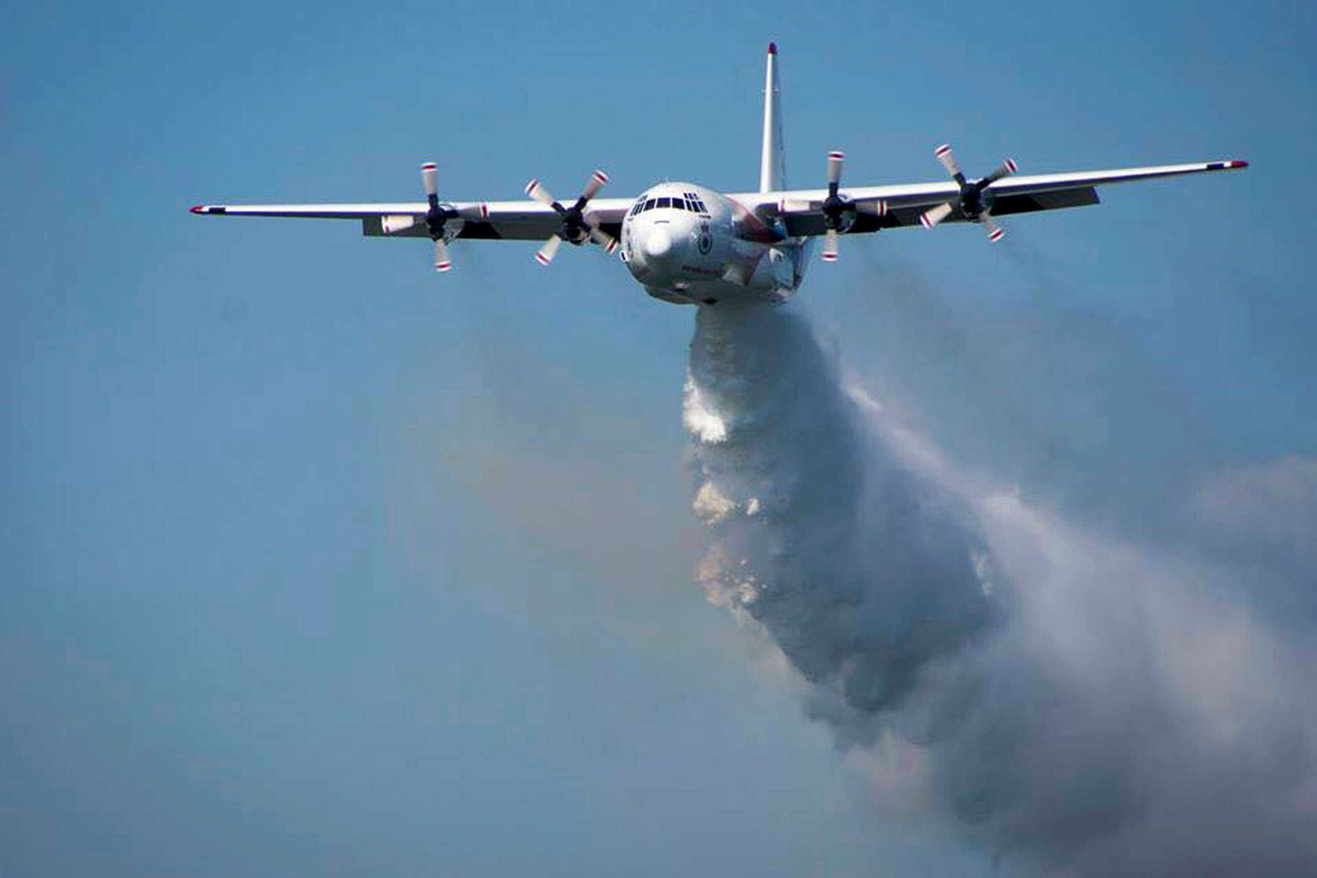 PHOTO: In this undated photo released from the Rural Fire Service, a C-130 Hercules plane called "Thor" drops water during a flight in Australia. 