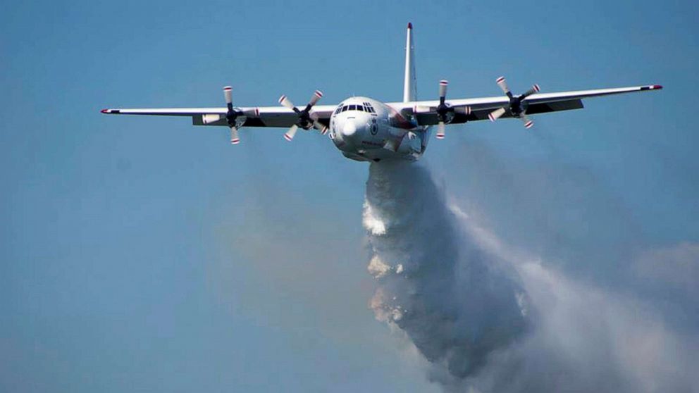 PHOTO: In this undated photo released from the Rural Fire Service, a C-130 Hercules plane called "Thor" drops water during a flight in Australia. 