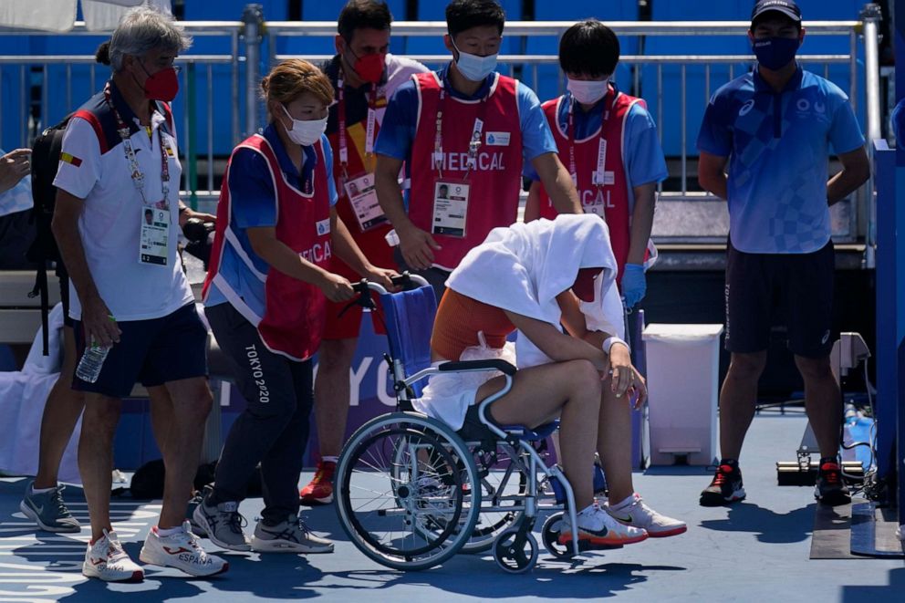 PHOTO: Paula Badosa, of Spain, is helped off the court in a wheelchair after retiring due to illness during the quarterfinals of the tennis competition at the 2020 Summer Olympics, Wednesday, July 28, 2021, in Tokyo, Japan.