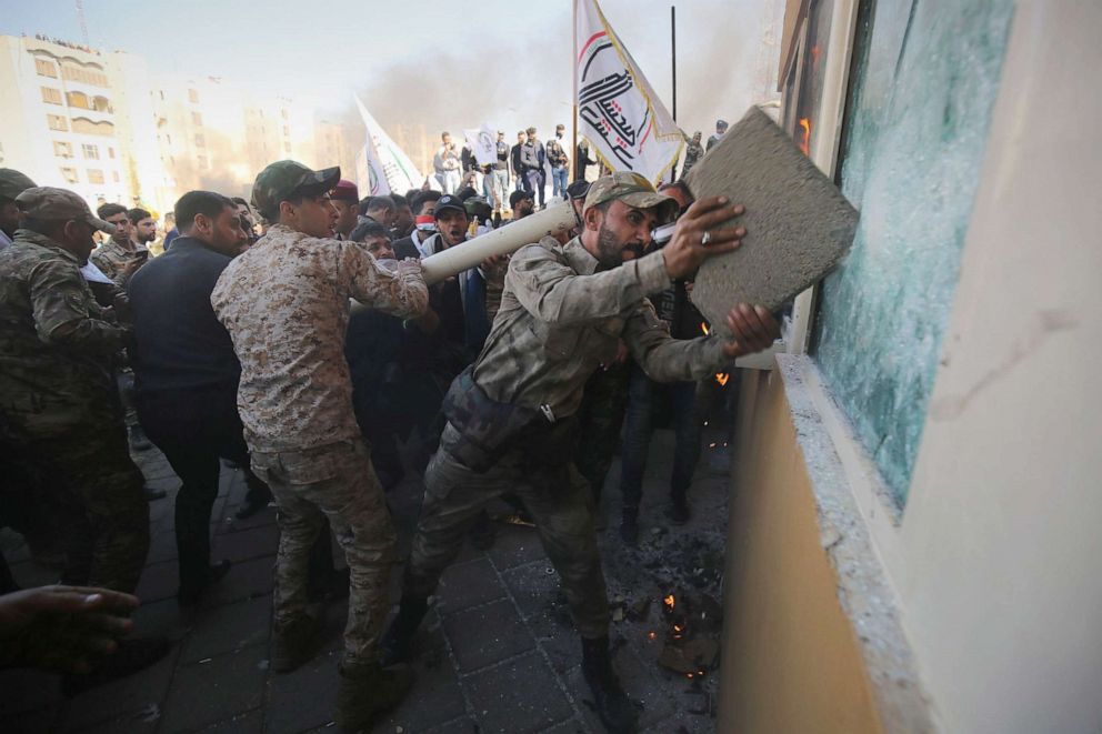 PHOTO: Members the Hashed al-Shaabi, a mostly Shiite network of local armed groups trained and armed by powerful neighbour Iran, smash the bullet-proof glass of the U.S. embassy's windows in Baghdad after breaching the outer wall, Dec. 31, 2019.