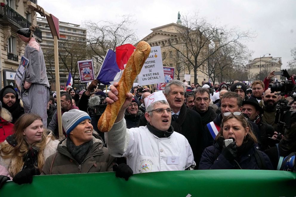 PHOTO: A baker clutches a baguette during a demonstration Monday, Jan. 23, 2023, in Paris.