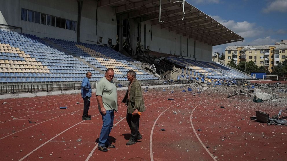 PHOTO: Employees stand at a stadium damaged by a Russian military strike, amid Russia's attack on Ukraine, in Bakhmut, Ukraine, on July 12, 2022.