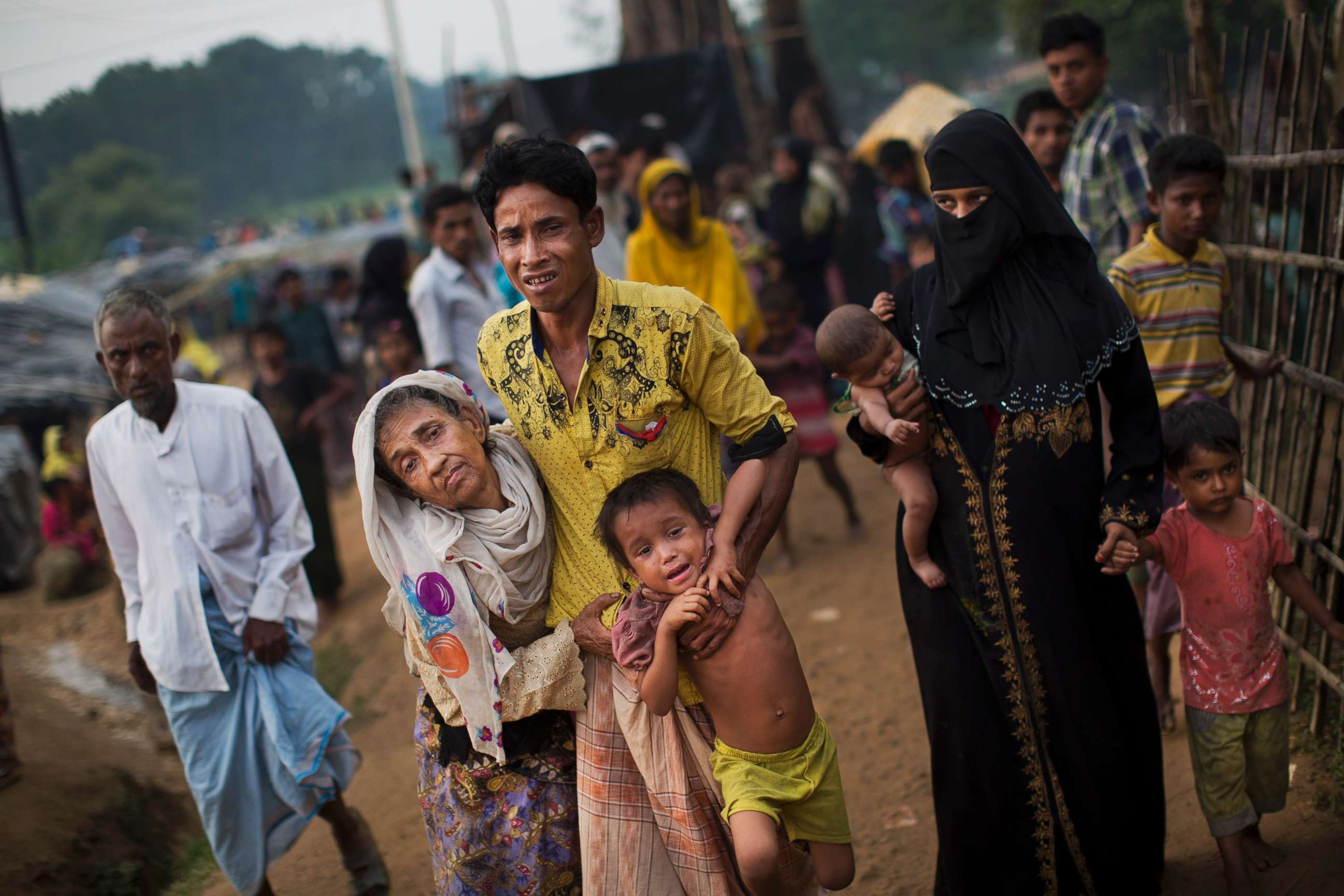 PHOTO: An exhausted Rohingya helps an elderly family member and a child as they arrive at Kutupalong refugee camp after crossing from Myanmmar to the Bangladesh side of the border, in Ukhia, Sept. 5, 2017.