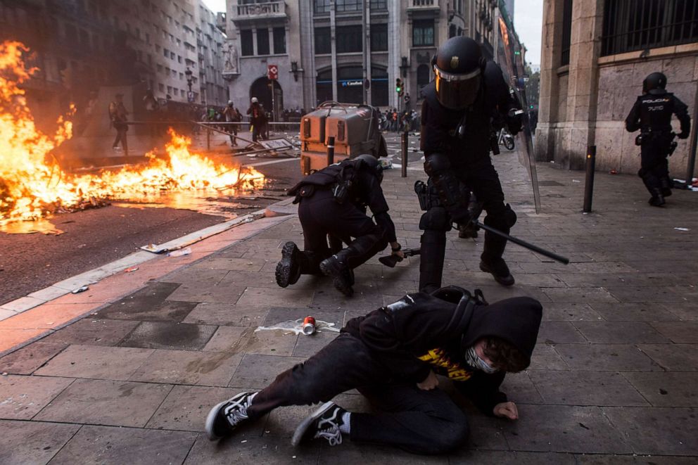 PHOTO: Police repeatedly hit a fallen protester. On the left a policeman fallen on the ground when charging against the protesters, in Barcelona, Spain, on October 18, 2019.