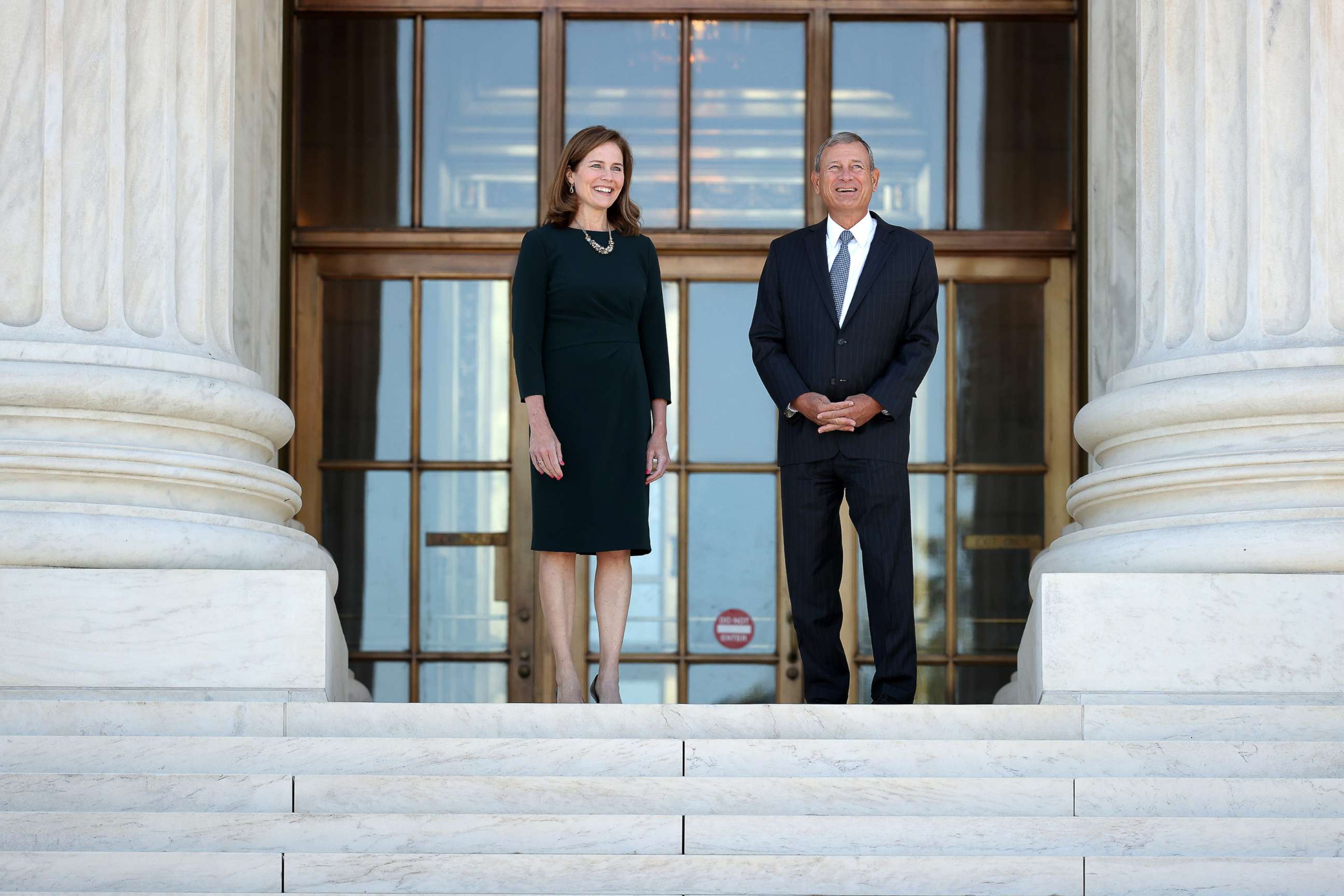 PHOTO: U.S. Supreme Court Associate Justice Amy Coney Barrett, left, and Chief Justice John Roberts pose for photos at the top of the steps of the west side of the Supreme Court following her investiture ceremony on Oct. 01, 2021, in Washington, DC.
