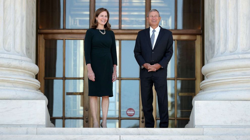 PHOTO: U.S. Supreme Court Associate Justice Amy Coney Barrett, left, and Chief Justice John Roberts pose for photos at the top of the steps of the west side of the Supreme Court following her investiture ceremony on Oct. 01, 2021, in Washington, DC.