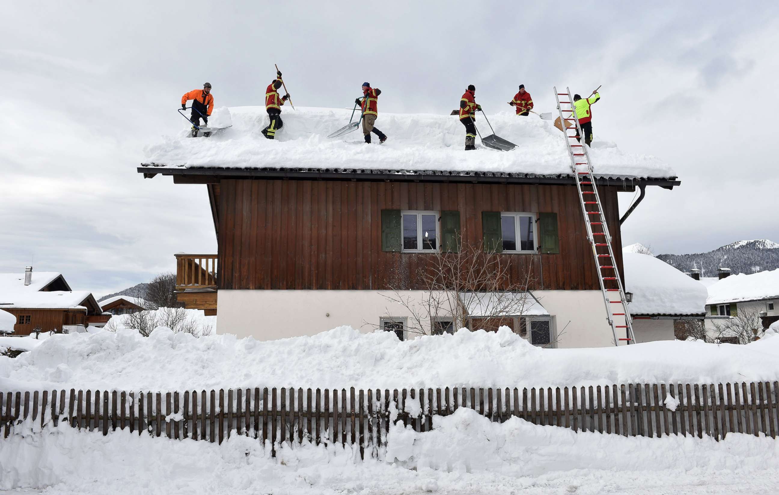 PHOTO: Firefighter helpers remove snow from a rooftop in the small Bavarian village of Kruen near Garmisch-Partenkirchen, Germany, Jan. 15, 2019.