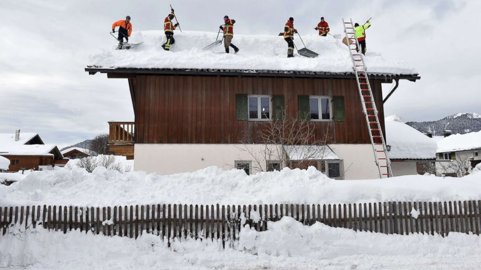 PHOTO: Firefighter helpers remove snow from a rooftop in the small Bavarian village of Kruen near Garmisch-Partenkirchen, Germany, Jan. 15, 2019.
