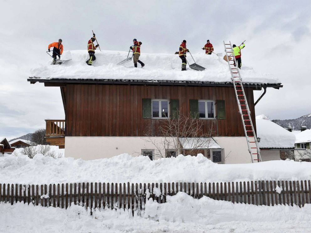PHOTO: Firefighter helpers remove snow from a rooftop in the small Bavarian village of Kruen near Garmisch-Partenkirchen, Germany, Jan. 15, 2019.