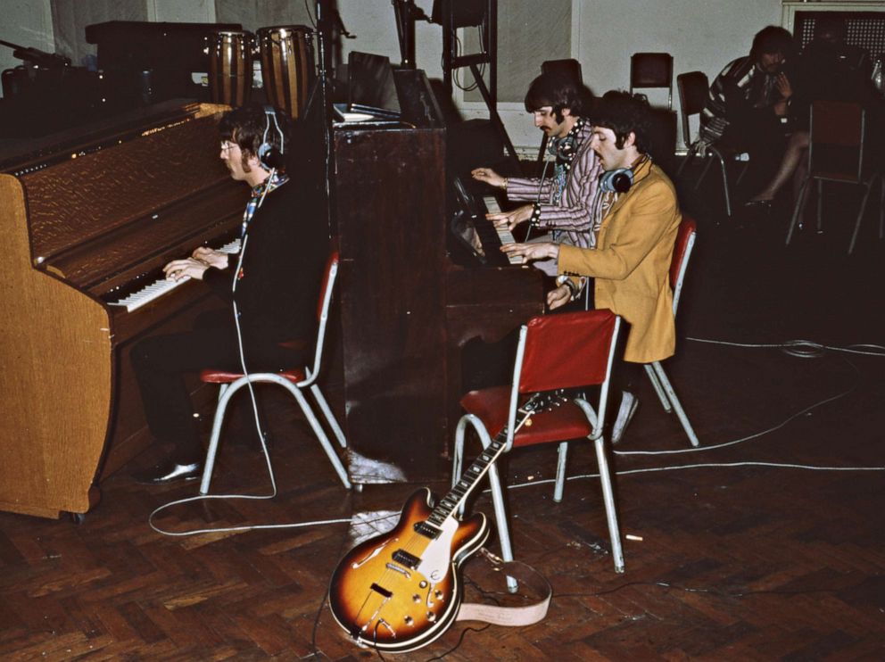 PHOTO: The Beatles play pianos at Abbey Road Studios (originally called EMI Studios) in London, circa 1967. Left to right, John Lennon, Ringo Starr and Paul McCartney. George Harrison is sitting in the background.