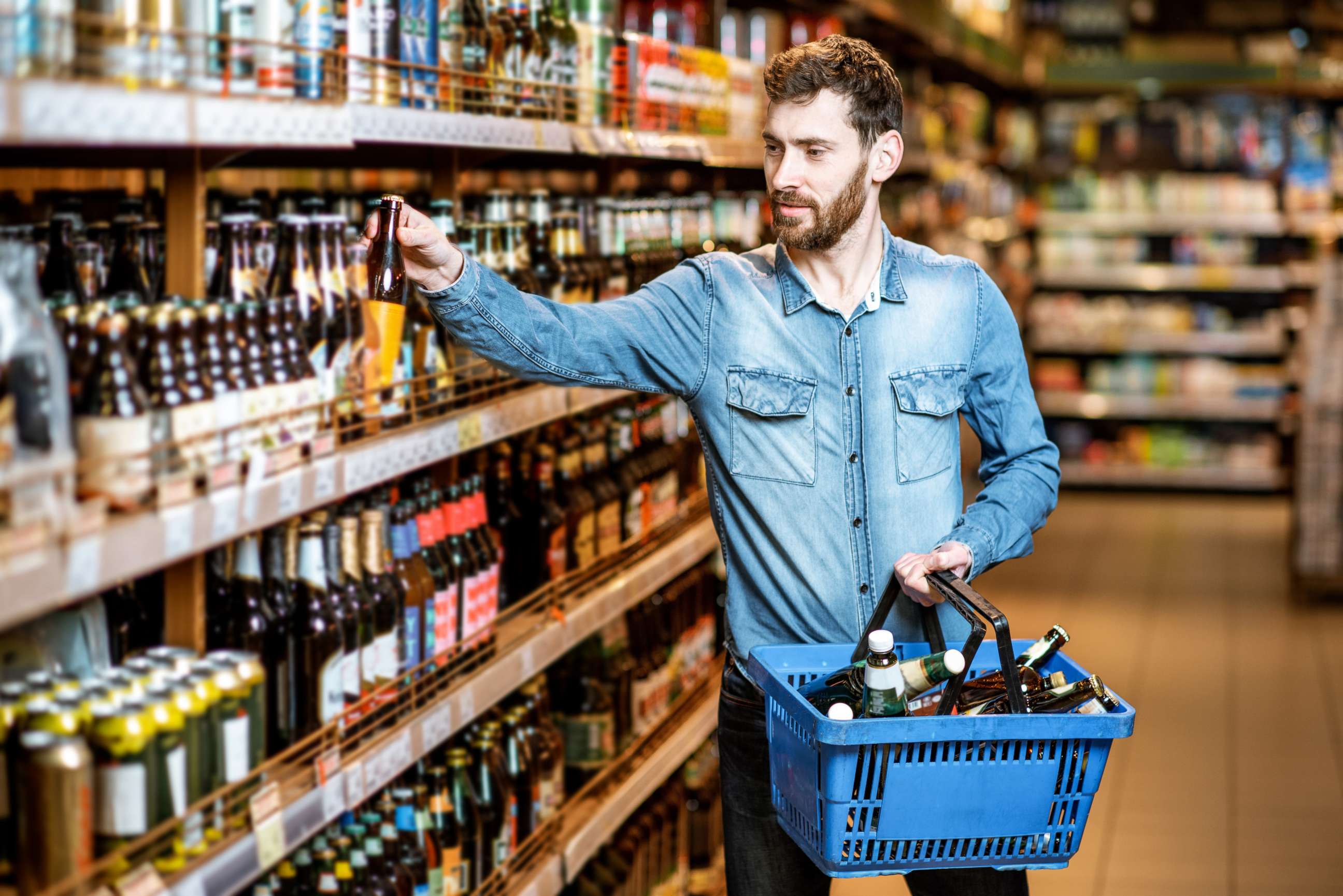 PHOTO: A man chooses a beer from a shelf in this stock photo.