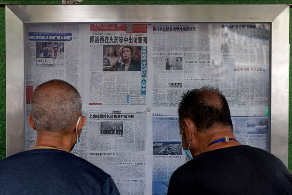 PHOTO: Men read the Global Times newspaper that features a front page article about U.S. House of Representatives Speaker Nancy Pelosi's Asia tour at a street display wall in Beijing, China, August 1, 2022.