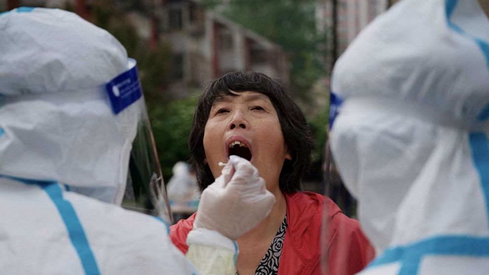 PHOTO: A resident has a sample taken to be tested for COVID-19 at a swab collection site in Beijing, April 25, 2022.