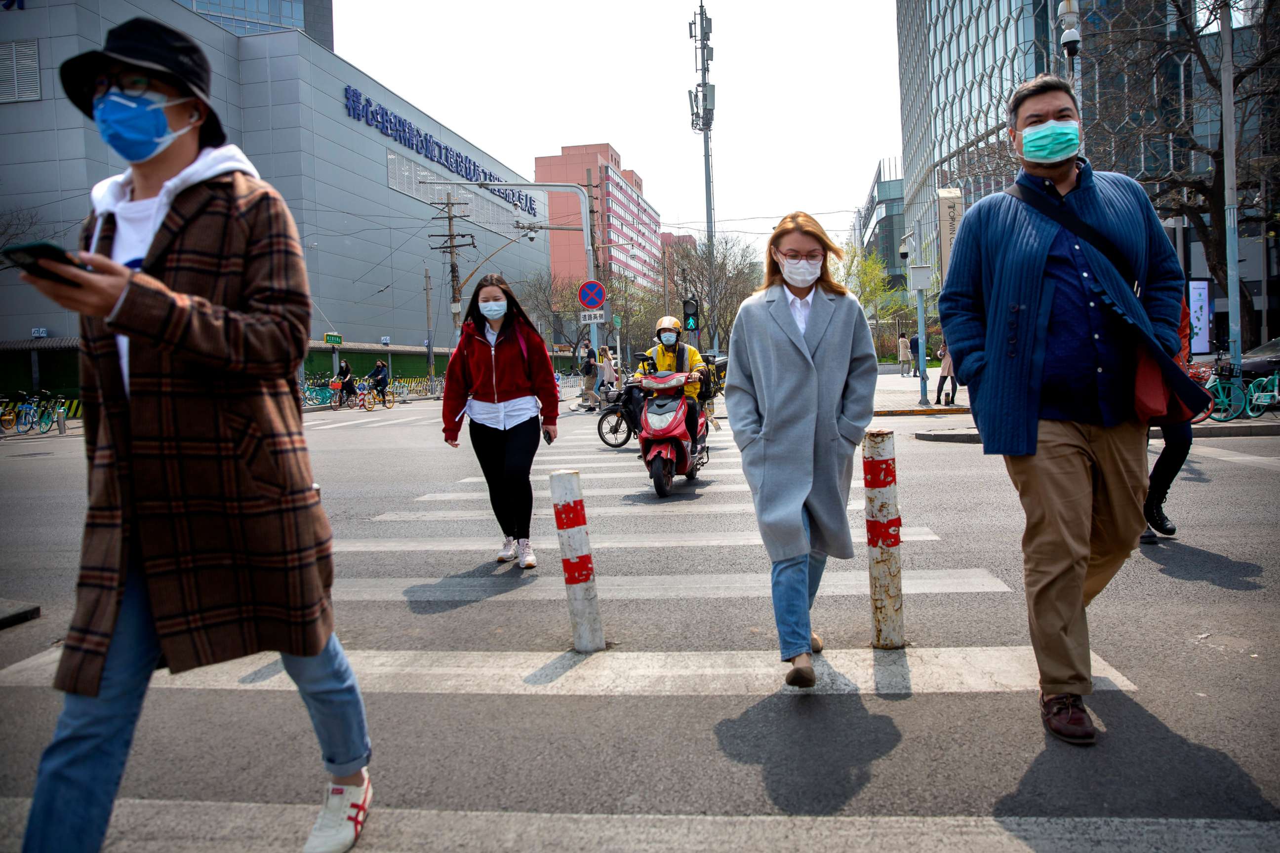 PHOTO: People wear face masks as they walk across an intersection in Beijing, China, on April 7, 2020.
