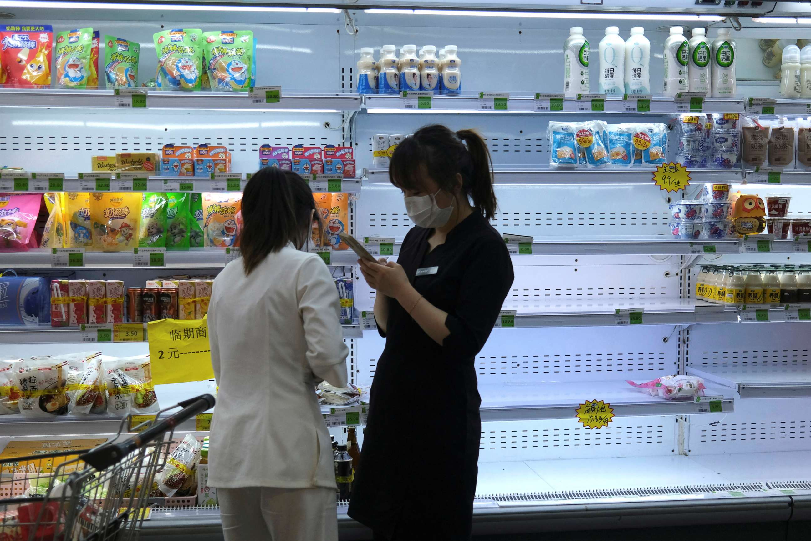 PHOTO: Customers shop in front of a half-empty freezer for diary products, following the COVID-19 outbreak in Beijing, China, April 25, 2022.