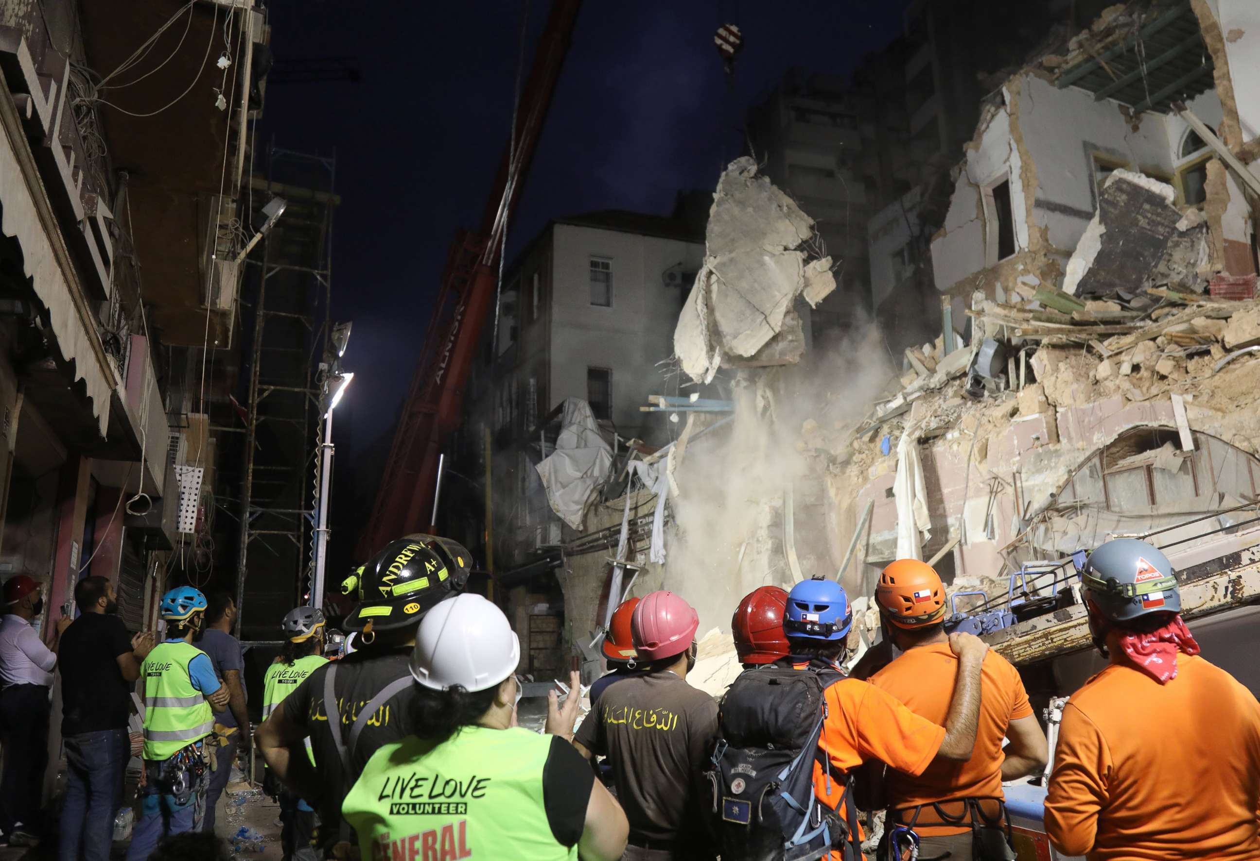 PHOTO: Lebanese and Chilean rescue workers watch as a crane lifts pieces of cement from a damaged building in search of possible survivors from a massive explosion earlier this month in Beirut, Sept. 4, 2020.