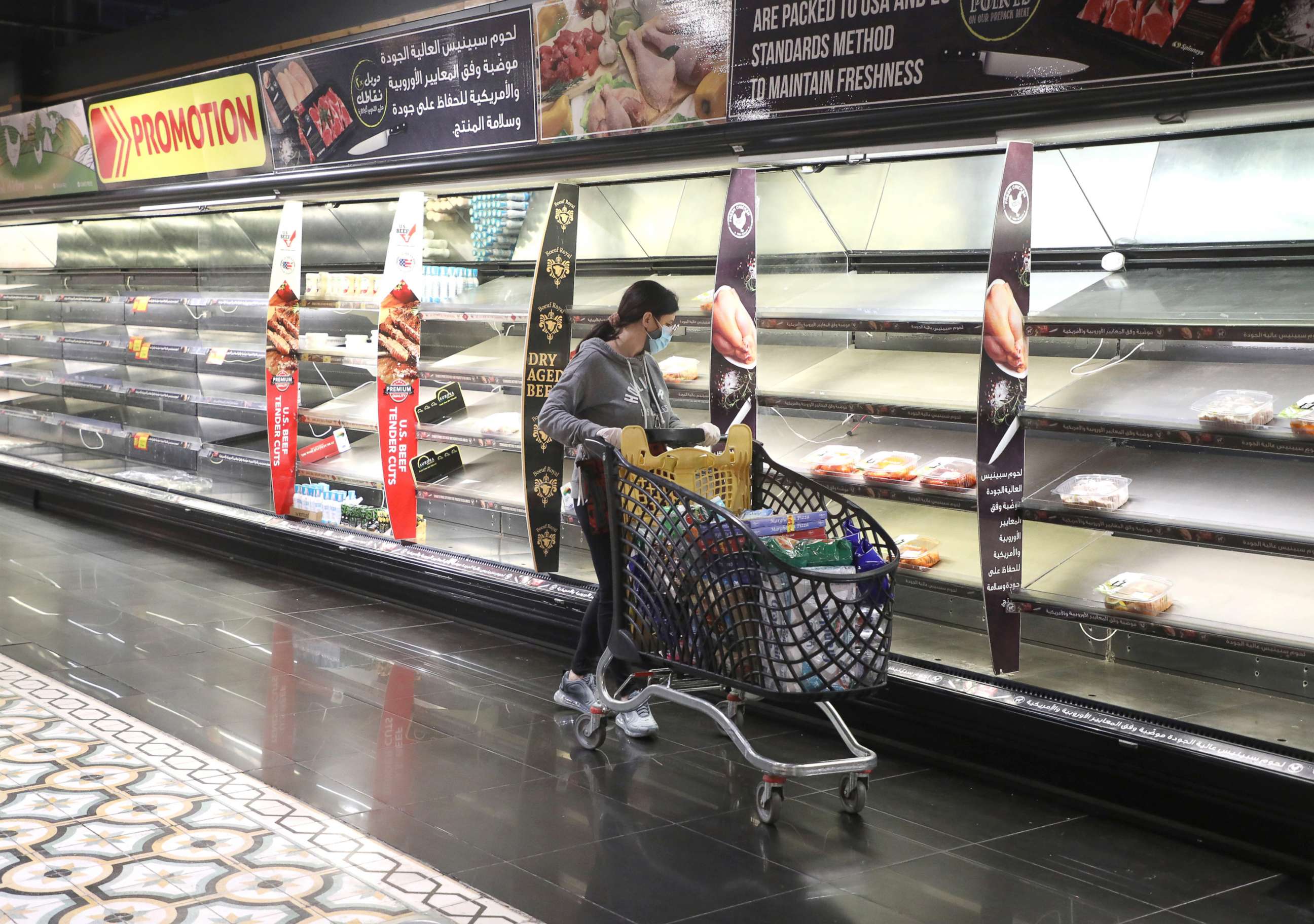 PHOTO: A customer pushes her trolley next to near empty shelves after people hoarded food as authorities are discussing the latest measures to implement to curb the spread of COVID-19, in Beirut, Lebanon, Jan. 11, 2021.