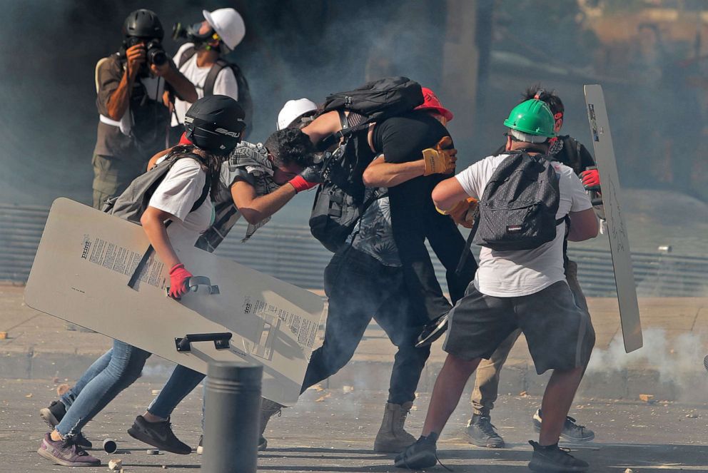 PHOTO: Protesters carry a wounded demonstrators away from clashes in downtown Beirut on Aug. 8, 2020, following a demonstration against political leadership they blame for a massive explosion that killed more than 150 people and disfigured the city.